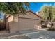 View of the two-car garage featuring a neutral color palette and desert landscaping at 9234 W Hedge Hog Pl, Peoria, AZ 85383