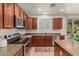 Modern kitchen with stainless steel appliances, granite countertops, and wood cabinetry at 9234 W Hedge Hog Pl, Peoria, AZ 85383