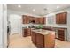 Well-lit kitchen features an island, tile flooring, stainless steel appliances, and wood cabinetry at 9234 W Hedge Hog Pl, Peoria, AZ 85383