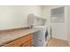 Bright laundry room with a washer, dryer, countertop, cabinets and tile flooring at 9234 W Hedge Hog Pl, Peoria, AZ 85383