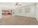 Bright living room with ceiling fan, carpet flooring, and view to kitchen with island at 9234 W Hedge Hog Pl, Peoria, AZ 85383