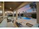 Outdoor patio with seating area overlooking a serene pool with waterfall feature at 14424 N 64Th Pl, Scottsdale, AZ 85254