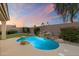Backyard pool with a charming rock waterfall feature surrounded by lush landscaping at 14424 N 64Th Pl, Scottsdale, AZ 85254