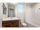 Bright bathroom featuring a tiled shower-tub, dark vanity with a large mirror, white walls, and a clear window at 21278 N 272Nd Ave, Buckeye, AZ 85396
