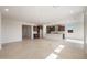 Open floor plan integrating the living area and kitchen, featuring sleek cabinetry, a large island, and neutral tile flooring at 21278 N 272Nd Ave, Buckeye, AZ 85396