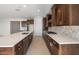 Stylish kitchen with dark wood cabinets, stainless steel appliances, and a white quartz countertop island at 21278 N 272Nd Ave, Buckeye, AZ 85396
