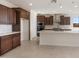 A modern kitchen featuring dark wood cabinets, stainless steel appliances, and a large center island at 21278 N 272Nd Ave, Buckeye, AZ 85396