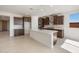 Spacious kitchen with stainless appliances, dark wood cabinets, large island and herringbone backsplash at 21278 N 272Nd Ave, Buckeye, AZ 85396