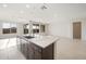 Open living room adjacent to kitchen with stone countertops and island with sink at 21278 N 272Nd Ave, Buckeye, AZ 85396
