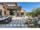 Outdoor patio features a pool, dining, fireplace and lounge areas surrounded by desert landscaping and blue skies at 10057 E Blue Sky Dr, Scottsdale, AZ 85262