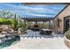 Outdoor patio features a pool, dining, fireplace and lounge areas surrounded by desert landscaping and blue skies at 10057 E Blue Sky Dr, Scottsdale, AZ 85262