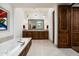 Spacious bathroom featuring double vanity, soaking tub, and custom wood accents at 10057 E Blue Sky Dr, Scottsdale, AZ 85262