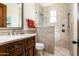 Elegant bathroom featuring a walk-in shower, stone tile, and a double vanity with warm wood cabinetry at 10057 E Blue Sky Dr, Scottsdale, AZ 85262