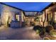 Desert home featuring a cozy courtyard with stone details and lush, well-lit desert landscaping at 10057 E Blue Sky Dr, Scottsdale, AZ 85262