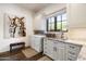 Functional laundry room with white cabinets, granite countertop, and stainless steel washer and dryer at 10057 E Blue Sky Dr, Scottsdale, AZ 85262