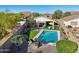 This backyard features a pool, an American flag, an outdoor lounge, and low-maintenance landscaping at 10224 S 175Th Ave, Goodyear, AZ 85338