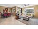 Comfortable living room with large windows, tile floors, and stylish furnishings, adjacent to dining area at 10224 S 175Th Ave, Goodyear, AZ 85338