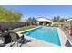 Inviting backyard oasis with a sparkling pool, artificial turf, and lounge chairs for ultimate relaxation at 10224 S 175Th Ave, Goodyear, AZ 85338