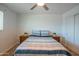 Inviting bedroom with neutral tones, brick accent wall, ceiling fan, and comfortable furnishings at 10713 E Oasis Dr, Mesa, AZ 85208