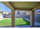 Covered patio overlooking a backyard featuring artificial grass, brick pavers and block wall fencing at 10817 W Pierson St, Phoenix, AZ 85037