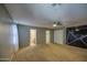 Bedroom featuring neutral colored walls, carpet flooring, ceiling fan and entrances to bathroom and closet at 10817 W Pierson St, Phoenix, AZ 85037