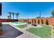 Backyard featuring a sparkling pool, fire pit, and palm trees at 1266 S Harrington St, Gilbert, AZ 85233