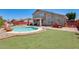 Spacious backyard with manicured artificial turf, a pool, patio, outdoor grill, and cozy seating under the covered patio at 1266 S Harrington St, Gilbert, AZ 85233