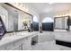 Bright bathroom with marble floors, dual sinks, vanity area, soaking tub, and large windows for plenty of light at 1266 S Harrington St, Gilbert, AZ 85233