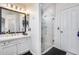 Elegant bathroom featuring a glass-enclosed shower, white vanity with granite countertop, and a framed mirror at 1266 S Harrington St, Gilbert, AZ 85233