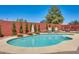 Backyard pool featuring a pebble-stone surround, brick trim and a decorative brick wall with trees at 1266 S Harrington St, Gilbert, AZ 85233