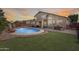 Inviting backyard oasis with a sparkling pool, lush grass, and covered patio for relaxation and entertaining at 1266 S Harrington St, Gilbert, AZ 85233