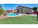 Inviting backyard oasis with a sparkling pool, lush grass, and covered patio for relaxation and entertaining at 1266 S Harrington St, Gilbert, AZ 85233