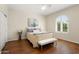 Comfortable bedroom with a ceiling fan, a large arched window, and elegant, neutral décor at 12738 W Nogales Dr, Sun City West, AZ 85375