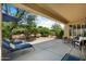 Relaxing covered patio with lounge chairs and outdoor seating overlooking the backyard at 12738 W Nogales Dr, Sun City West, AZ 85375
