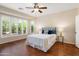 Bright main bedroom with hardwood floors, shuttered windows, and ceiling fan at 12738 W Nogales Dr, Sun City West, AZ 85375