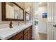 Bathroom with a wood framed mirror, white countertop and cabinets with an exit to the patio area at 14037 E Coyote Rd, Scottsdale, AZ 85259