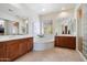 Bathroom features white countertops, wood cabinets, a soaking tub, and glass-enclosed shower at 14037 E Coyote Rd, Scottsdale, AZ 85259