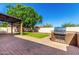 Landscaped backyard with artificial turf, brick pavers, built-in barbeque, a gazebo, and a storage shed at 14815 N 21St St, Phoenix, AZ 85022