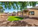 Spacious backyard featuring a covered patio, artificial turf, built-in barbecue, and desert landscaping at 14815 N 21St St, Phoenix, AZ 85022