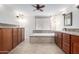 Bright bathroom boasts double sinks, tile floors, wood cabinets, granite counters, and a soaking tub at 14815 N 21St St, Phoenix, AZ 85022