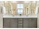 Bathroom vanity with dual sinks, gray cabinets, gold hardware, and large mirrors above at 1635 N 208Th Ave, Buckeye, AZ 85396