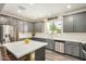 A modern kitchen featuring stainless steel appliances, gray cabinetry, and quartz countertops at 1635 N 208Th Ave, Buckeye, AZ 85396