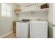 Functional laundry room with washer, dryer, built-in shelf, and ample lighting at 1635 N 208Th Ave, Buckeye, AZ 85396