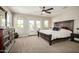 Bright main bedroom with balcony doors, and dark wood furniture against neutral walls at 1635 N 208Th Ave, Buckeye, AZ 85396