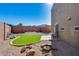 Backyard features desert landscaping, a small patch of grass, and a cute stone firepit at 17606 N 17Th Pl # 1054, Phoenix, AZ 85022
