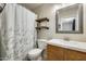 Cozy bathroom featuring wood shelves, a modern sink, and a decorative floral shower curtain at 17606 N 17Th Pl # 1054, Phoenix, AZ 85022