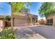 Two-story home with a two-car garage, desert landscaping, and a tile roof sits on a sunny day at 17606 N 17Th Pl # 1054, Phoenix, AZ 85022