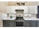 Well-lit kitchen with stainless steel oven/range, white upper cabinets, and gray lower cabinets at 17606 N 17Th Pl # 1054, Phoenix, AZ 85022