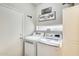 Functional laundry room with washer, dryer, laundry themed artwork, and storage at 17606 N 17Th Pl # 1054, Phoenix, AZ 85022