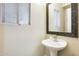Bright powder room with pedestal sink, large mirror, and window for natural light at 17606 N 17Th Pl # 1054, Phoenix, AZ 85022